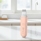 Pink electronic device on a white surface with a blurred background