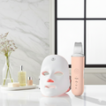 Beauty device and skincare products on a table with a neutral background